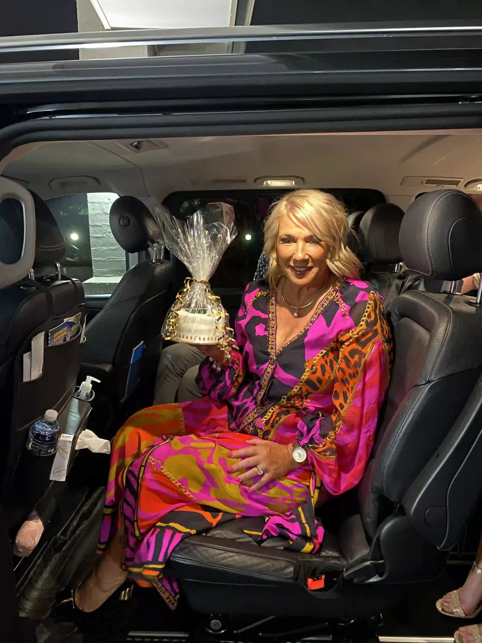 Smiling woman stepping out of chauffeur-driven car in Brisbane