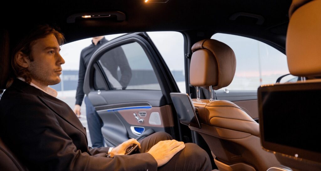 Professional chauffeur assisting executive during Brisbane business class transfer