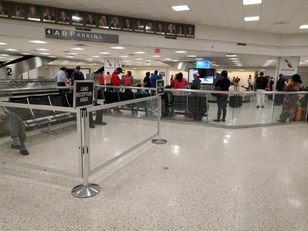 Chauffeur meeting passenger inside Australian airport terminal for airport transfer