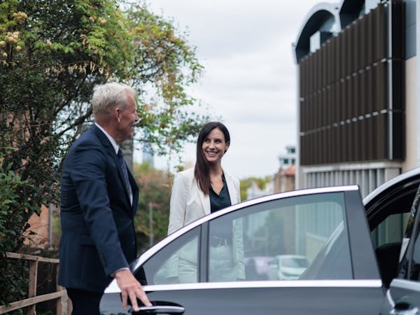 Airport chauffeur in Brisbane assisting passenger at terminal